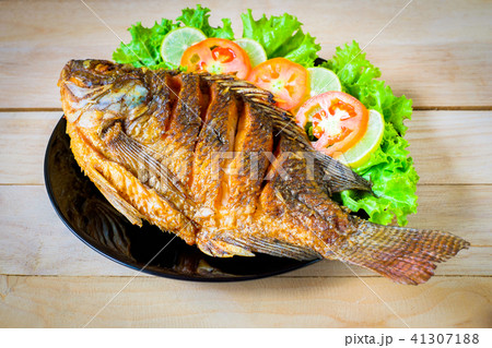 fried fish with vegetable on black dish. top view 41307188