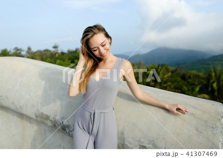 Young relaxed female person standing in mountains background. Young relaxed female person standing in mountains background. 41307469