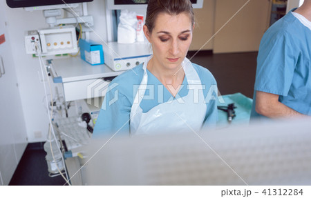 Internal specialist doctor looking at screen mid examination 41312284