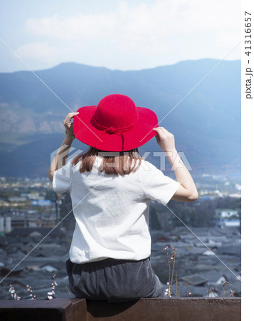 世界遺産　麗江古城　街並みを見つめる 赤い帽子の女性 41316657