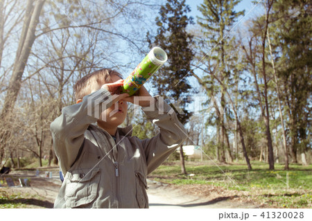 Boy looking at the kaleidoscope outdoors 41320028