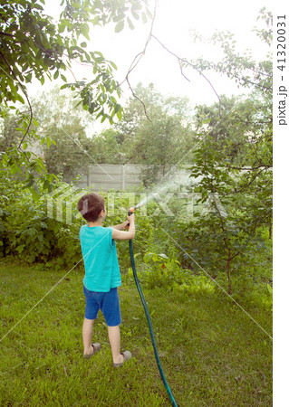 Boy playing with a sprinkler in the garden 41320031