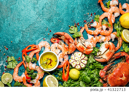 Fresh raw seafood - shrimps and crabs with herbs and spices on turquoise background. Copy space 41322713