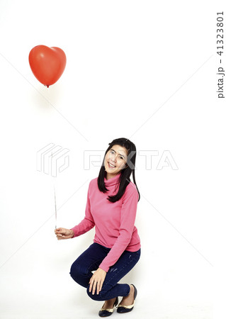 Young woman holding a red balloon 41323801