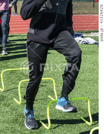 Stepping over yellow mini hurdles at practice 41326429