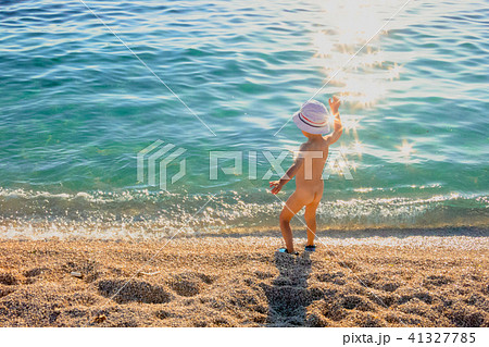 nudist beach little girl The child, a little girl playing on the beach. Stock 写真 ...