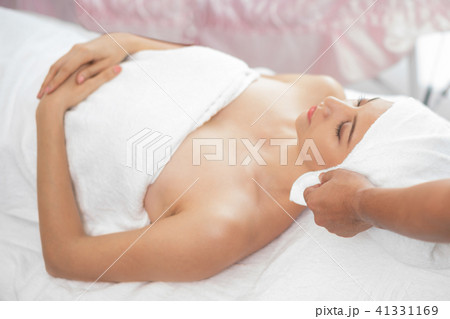Relaxed young woman lying on spa bed for massage. 41331169