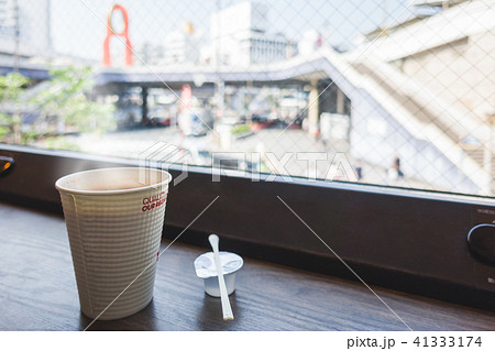 hot coffee, swizzle and syrup in front of window 41333174