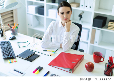 A young girl is sitting at the computer desk in the office. 41333372