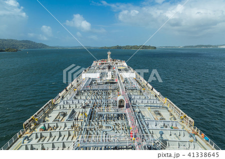 Oil tanker proceeding through Panama Canal by green jungle. 41338645