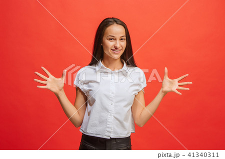The happy business woman standing and smiling against red background. 41340311