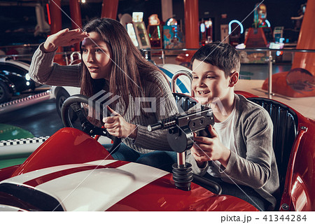 Smiling mother and son sitting on toy car 41344284