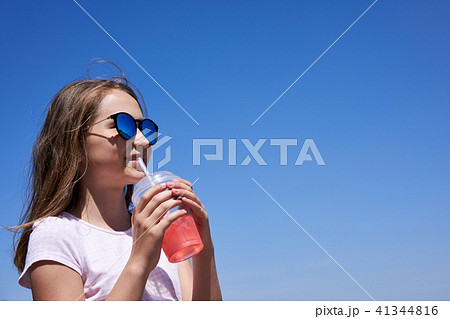 Girl in sunglasses drinking cold lemonade 41344816