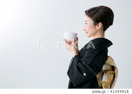 抹茶を飲む黒留袖の女性の写真素材