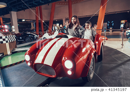 Wondered mother and son sitting on toy car Wondered mother and son sitting on toy car 41345197