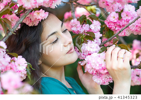 beautiful girl posing near pink sakura flowers as background, face closeup, spring landscape beautiful girl posing near pink sakura flowers as background, face closeup, spring landscape 41345323