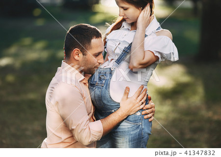 Man hugging and kissing pregnant wife's belly Man hugging and kissing pregnant wife's belly 41347832