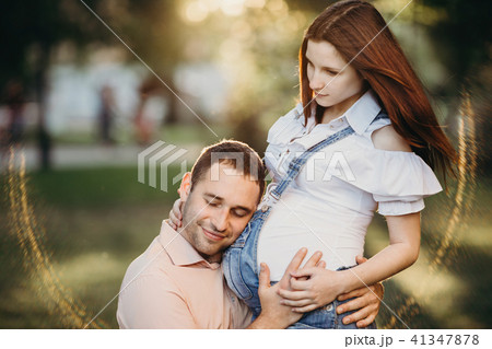 Father hearing baby moving inside pregnant belly Father hearing baby moving inside pregnant belly 41347878
