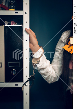 Womans hand handcuffed to metal rack. 41348846