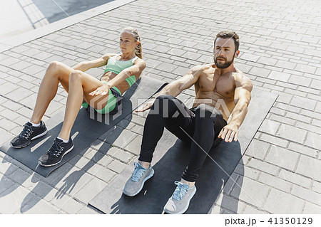 Fit fitness woman and man doing fitness exercises outdoors at city Fit fitness woman and man doing fitness exercises outdoors at city 41350129