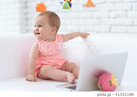 Smiling newborn baby pink dressed on sofa. 41352196