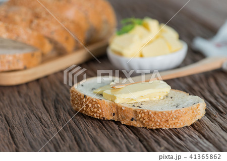 Sliced of Sesame bread with butter on wood board. 41365862