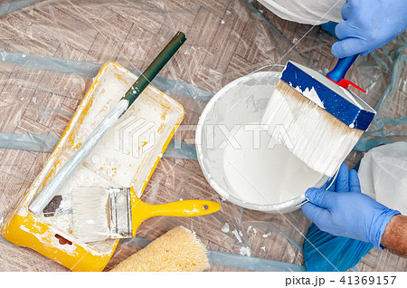 House painter at work prepares white paint 41369157