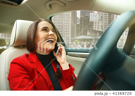Driving around city. Young attractive woman driving a car Driving around city. Young attractive woman driving a car 41369720