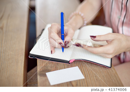 young freelancer woman writting plans in notebook at the table young freelancer woman writting plans in notebook at the table 41374006