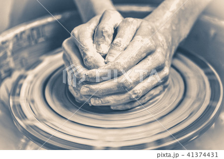 Old vintage photo. Master potter folded together hands sculpts a clay product Old vintage photo. Master potter folded together hands sculpts a clay product 41374431