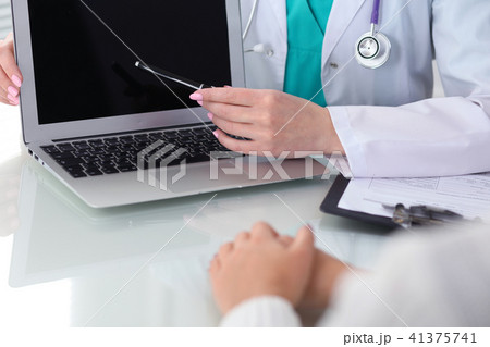 Doctor and patient, close-up.  Physician pointing into laptop computer screen. Medicine, healthcar 41375741