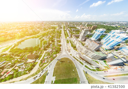 Aerial city view with crossroads and roads, houses, buildings, parks and parking lots. Sunny summer Aerial city view with crossroads and roads, houses, buildings, parks and parking lots. Sunny summer 41382500