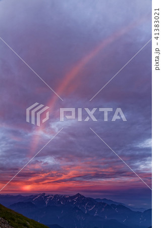 白馬岳山頂から見る朝焼けの剣 立山と虹の写真素材