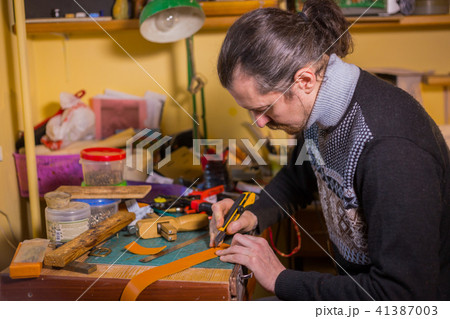 Skinner working with leather belt 41387003