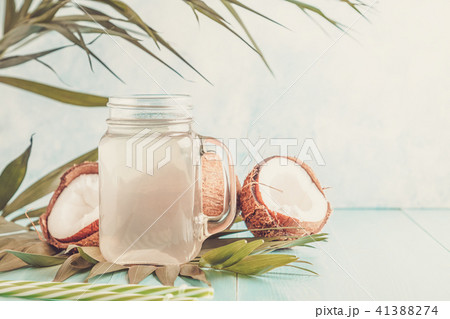 Coconut water and coconuts on a pastel background. Coconut water and coconuts on a pastel background. 41388274