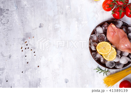 Ingredients for cooking Italian pasta with chicken and tomatoes with lemon slice and ice. Lean Ingredients for cooking Italian pasta with chicken and tomatoes with lemon slice and ice. Lean 41389139