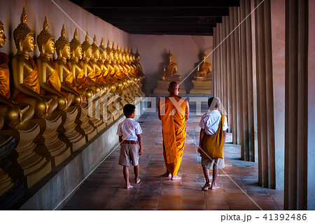 Monk and tow boy student at Golden buddha statue Monk and tow boy student at Golden buddha statue 41392486