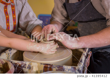 Potter showing how to work with ceramic in pottery studio 41395412