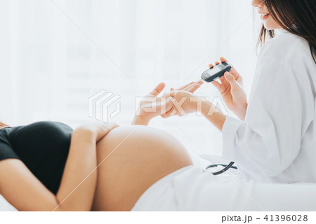 Doctor checking sugar level from pregnant woman Doctor checking sugar level from pregnant woman 41396028