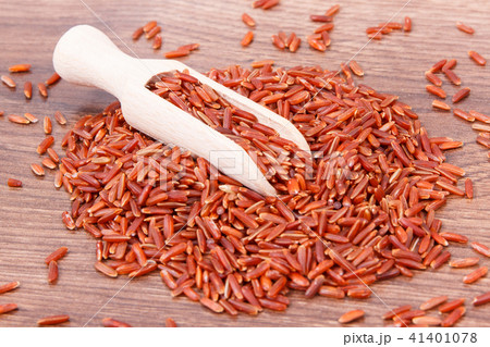 Brown rice with wooden scoop on board Brown rice with wooden scoop on board 41401078