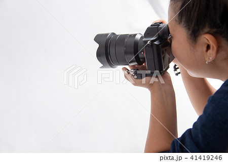 一眼カメラで写真を撮る若い女性　白バック 41419246