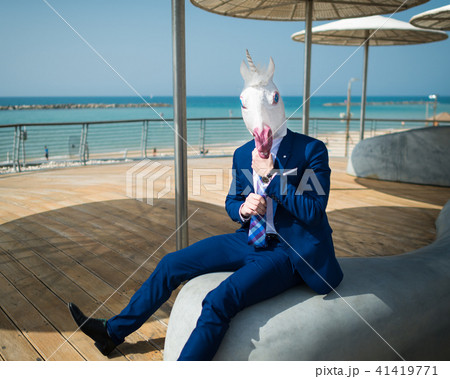 Young man is dressed up a suit under umbrellas Young man is dressed up a suit under umbrellas 41419771