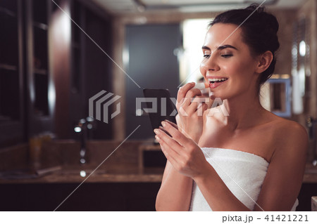 Delighted female beautifying herself before date Delighted female beautifying herself before date 41421221