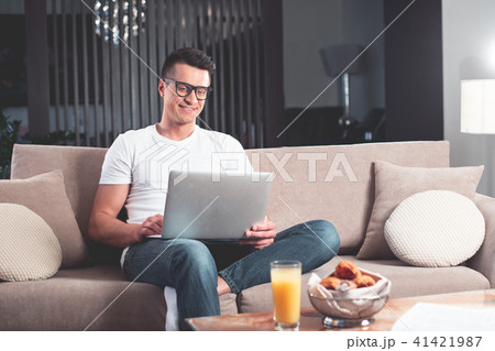 Joyful young man working on computer at home Joyful young man working on computer at home 41421987
