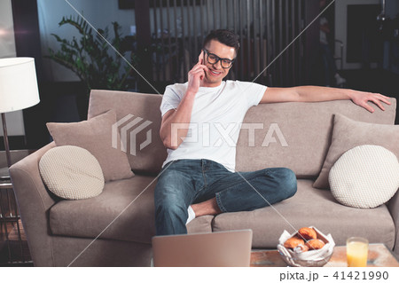 Relaxed guy communicating on smartphone at home  41421990