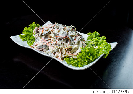 Chinese cuisine, salad with mushrooms, fried beef, pickles, lettuce in a white plate on a black 41422397