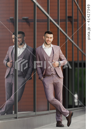 Businessman in city. Modern businessman. Confident young man in full suit standing outdoors Businessman in city. Modern businessman. Confident young man in full suit standing outdoors 41427349