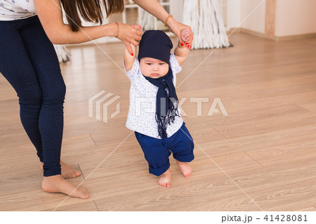mother holding baby's hands to help him to walk. First step concept mother holding baby's hands to help him to walk. First step concept 41428081