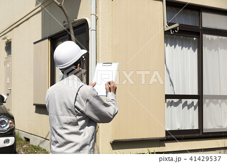 住宅とヘルメットの男性 現地調査の写真素材