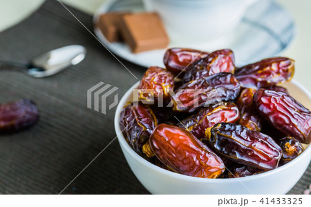 Sweet dried organic dates fruit in small bowl Sweet dried organic dates fruit in small bowl 41433325